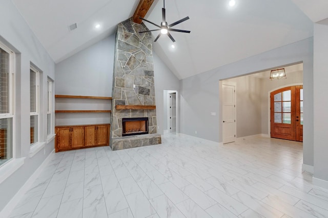 unfurnished living room featuring a fireplace, ceiling fan with notable chandelier, beam ceiling, and high vaulted ceiling