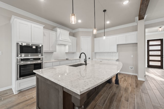 kitchen featuring a sink, white cabinetry, appliances with stainless steel finishes, custom exhaust hood, and wood tiled floor
