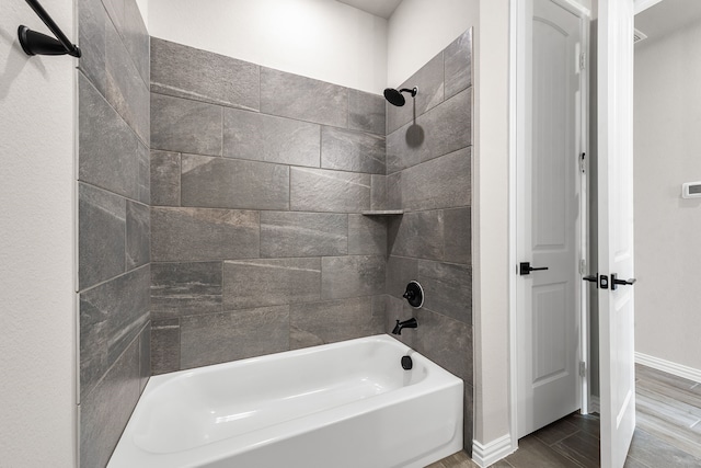 bathroom with baseboards and washtub / shower combination