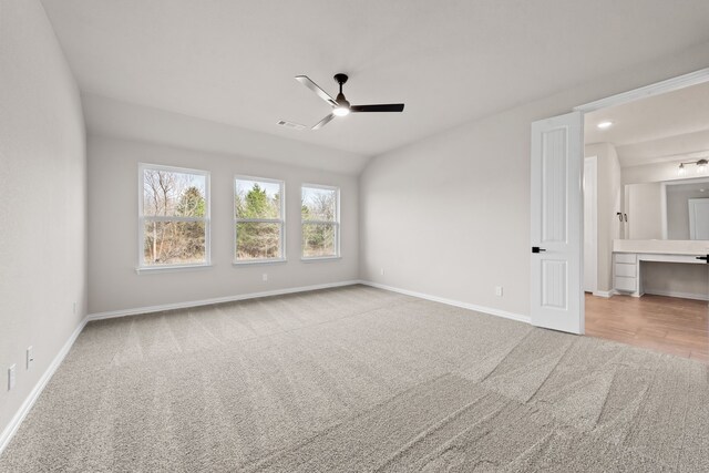 unfurnished bedroom with carpet flooring, visible vents, lofted ceiling, and baseboards