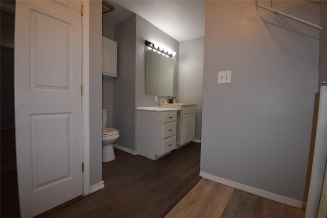 bathroom featuring vanity, wood-type flooring, and toilet