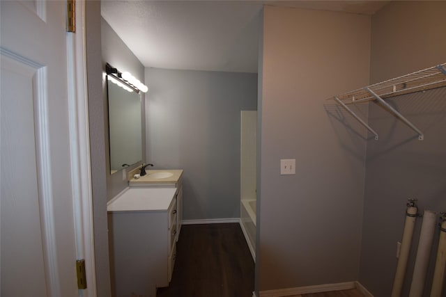 bathroom with a bathtub, hardwood / wood-style floors, and vanity