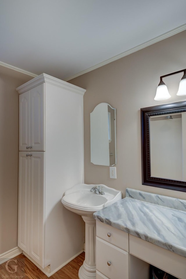 bathroom featuring baseboards, ornamental molding, and wood finished floors