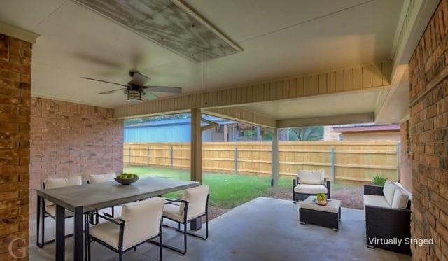 view of patio featuring outdoor dining area, a fenced backyard, and a ceiling fan