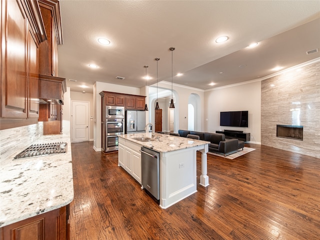 kitchen with light stone countertops, a kitchen island with sink, stainless steel appliances, and dark hardwood / wood-style floors