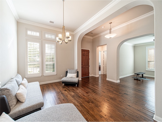 living area with crown molding, dark wood-type flooring, and an inviting chandelier