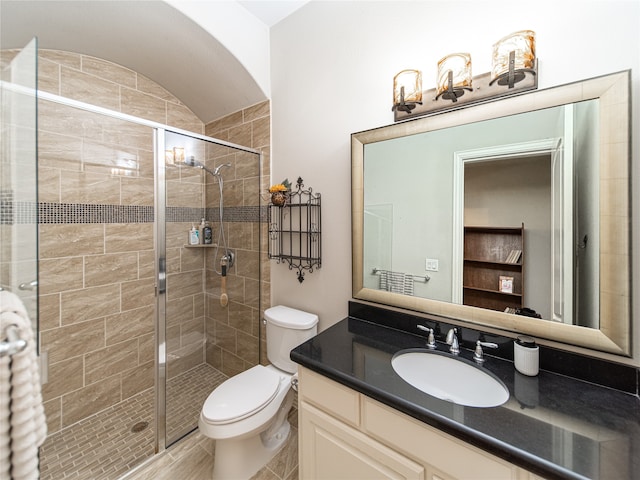 bathroom with vanity, toilet, and a shower with shower door