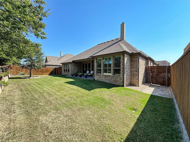 back of house with a lawn and a patio area