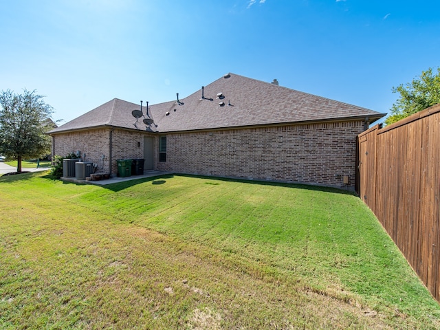 back of property featuring a yard and central air condition unit