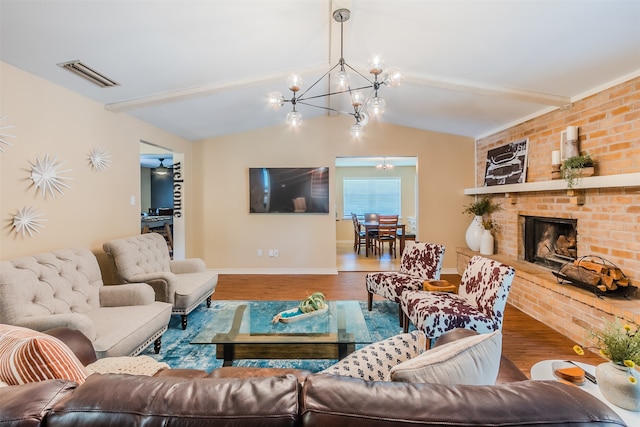 living room featuring a notable chandelier, lofted ceiling, a brick fireplace, and hardwood / wood-style floors