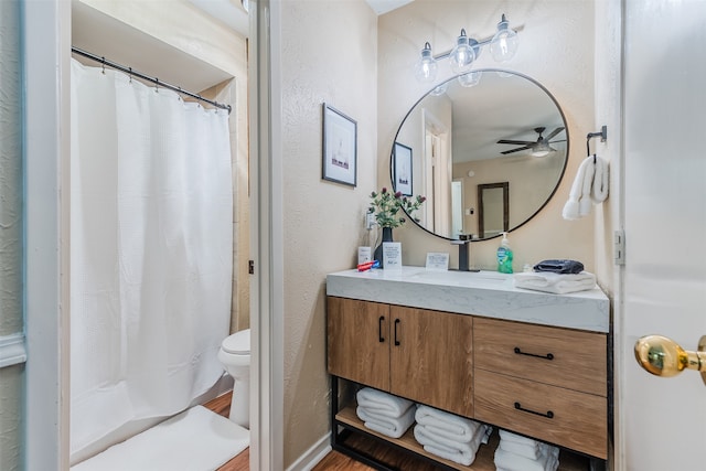 bathroom with toilet, vanity, wood-type flooring, and ceiling fan