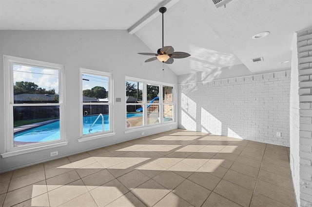 tiled empty room featuring brick wall, vaulted ceiling with beams, and ceiling fan