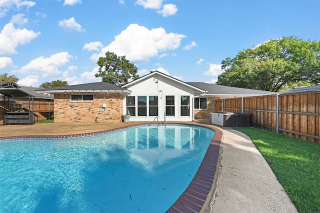 view of swimming pool with a hot tub