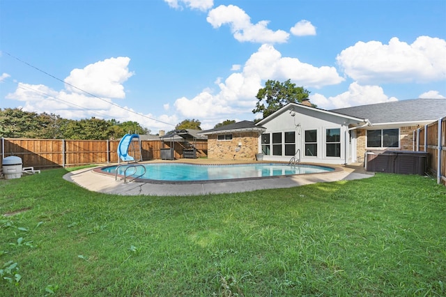 view of pool with a water slide and a lawn