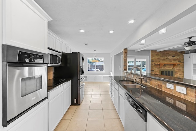 kitchen featuring tasteful backsplash, appliances with stainless steel finishes, sink, light tile patterned flooring, and white cabinetry