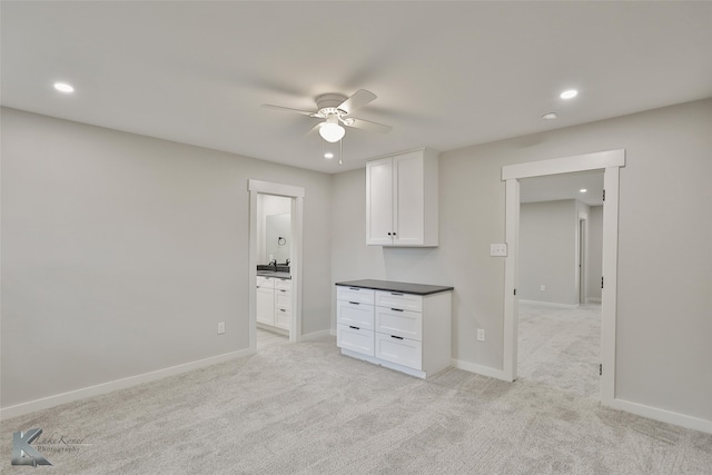 carpeted empty room with ceiling fan and sink