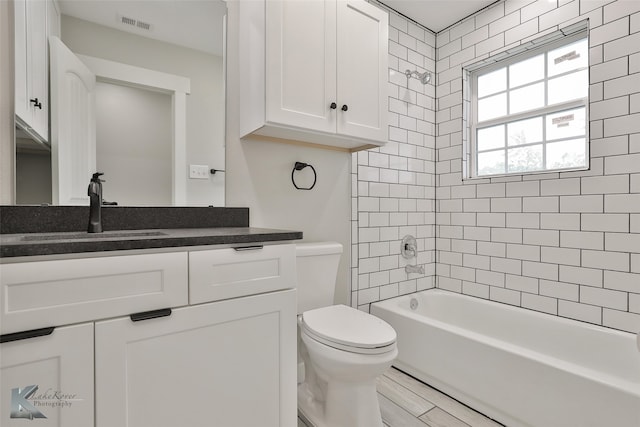 full bathroom featuring toilet, tiled shower / bath combo, and vanity