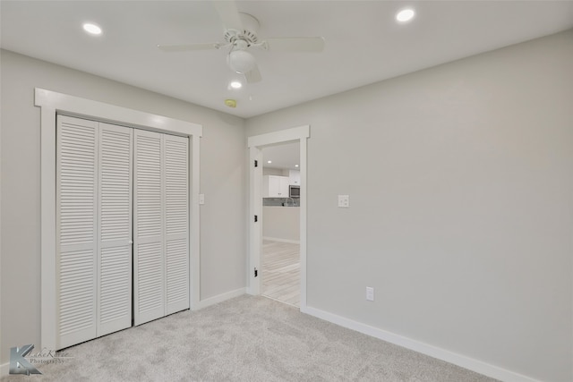 unfurnished bedroom with light carpet, a closet, and ceiling fan