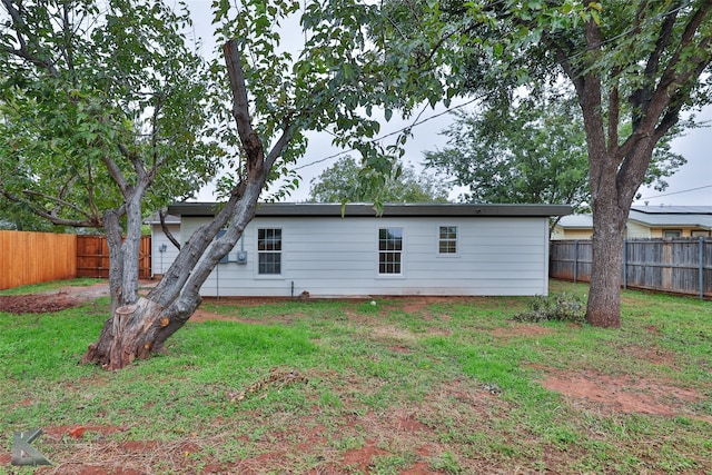 back of house with a lawn