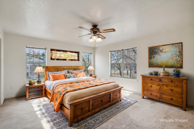 bedroom featuring multiple windows, ceiling fan, and light colored carpet