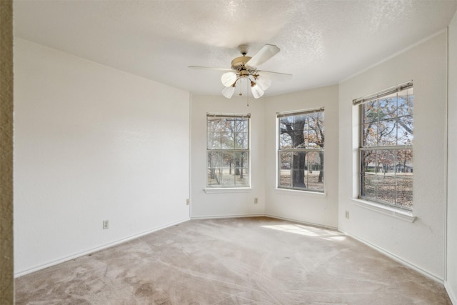 carpeted empty room featuring ceiling fan and a textured ceiling