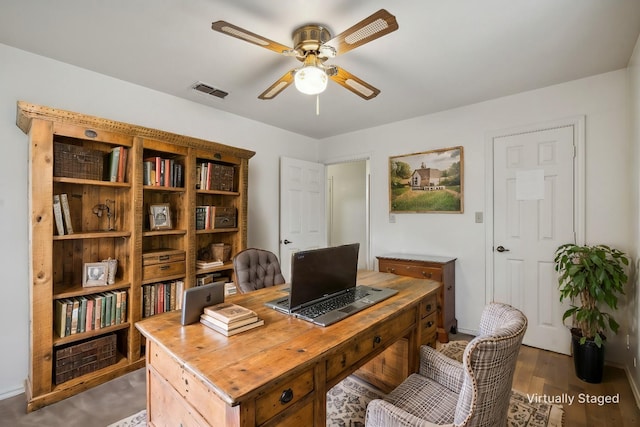 home office with ceiling fan and dark wood-type flooring