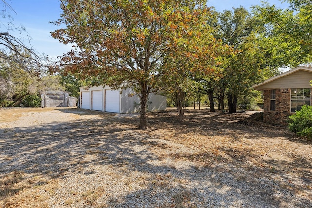 view of yard featuring a garage and an outbuilding