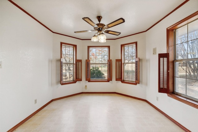 empty room with ceiling fan and crown molding