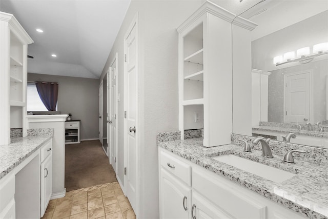 bathroom featuring vanity and lofted ceiling