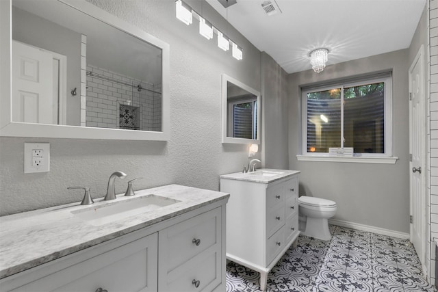 bathroom featuring vanity, a tile shower, toilet, and tile patterned flooring