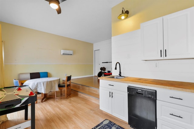 kitchen featuring white cabinetry, black dishwasher, sink, and light wood-type flooring