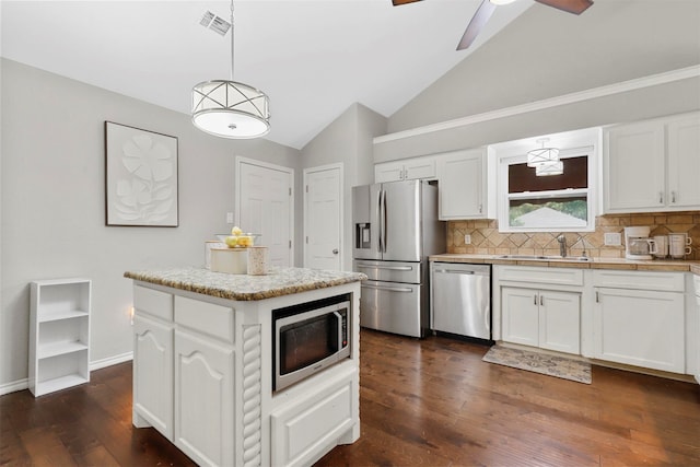 kitchen featuring a kitchen island, appliances with stainless steel finishes, white cabinetry, dark hardwood / wood-style floors, and decorative light fixtures