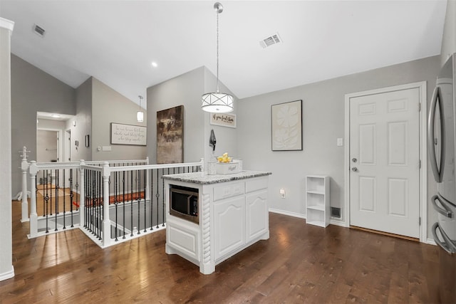 kitchen featuring stainless steel fridge, vaulted ceiling, pendant lighting, white cabinets, and dark hardwood / wood-style floors