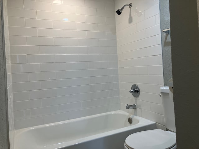 bathroom featuring toilet and tiled shower / bath combo