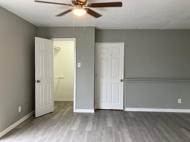 unfurnished bedroom featuring hardwood / wood-style flooring, a closet, and ceiling fan