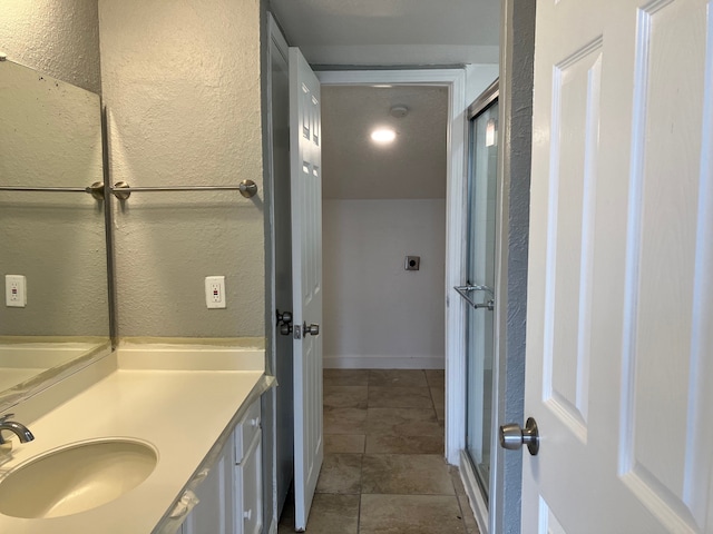 bathroom featuring vanity and a shower with door