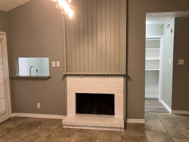 unfurnished living room with a textured ceiling, tile patterned floors, a fireplace, and vaulted ceiling