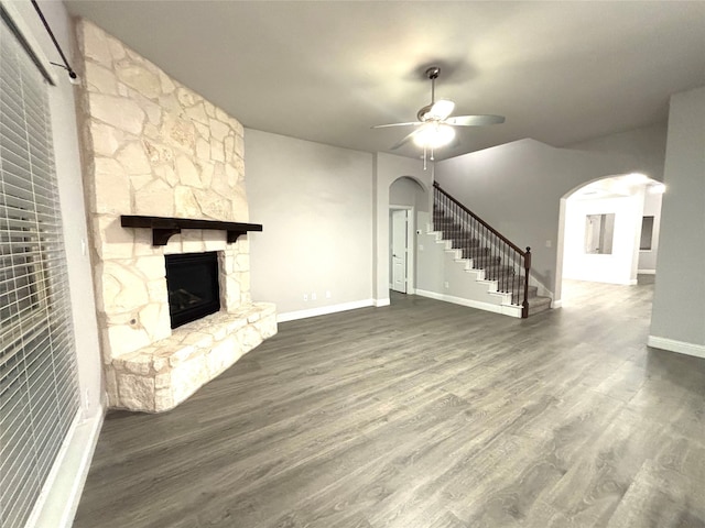 unfurnished living room with a fireplace, dark hardwood / wood-style flooring, and ceiling fan