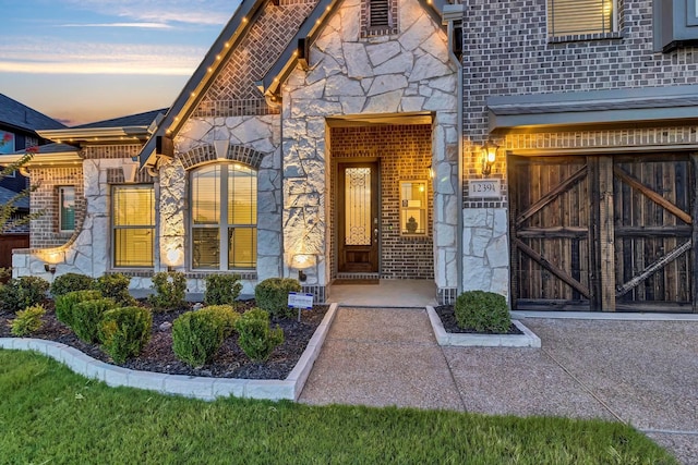 exterior entry at dusk featuring a garage