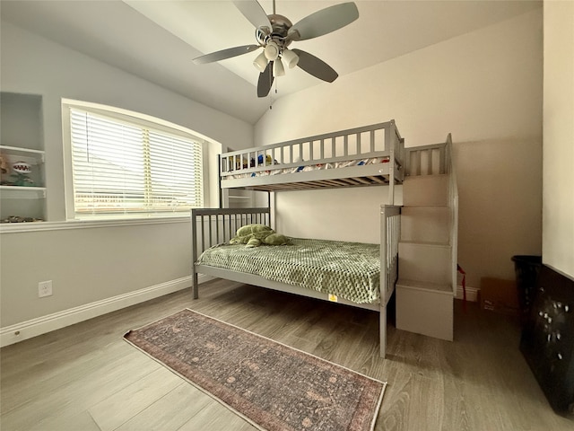 bedroom featuring wood-type flooring, vaulted ceiling, and ceiling fan