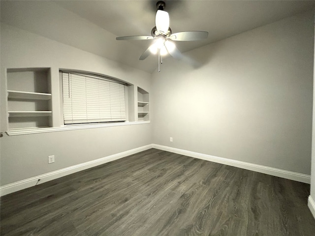 empty room with dark hardwood / wood-style floors, ceiling fan, and built in features