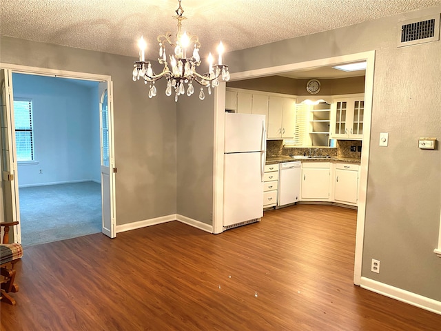 kitchen with white cabinetry, hanging light fixtures, dark hardwood / wood-style flooring, a textured ceiling, and white appliances