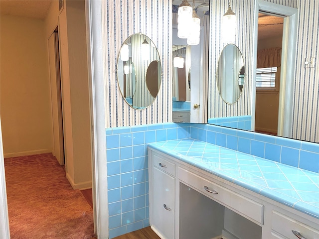 bathroom featuring vanity and tile walls