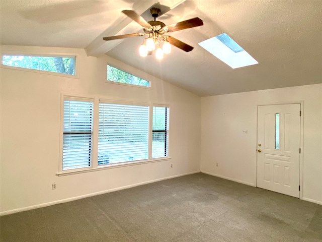 carpeted spare room with lofted ceiling with skylight and ceiling fan