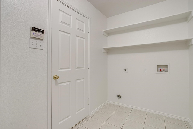 clothes washing area featuring electric dryer hookup, hookup for a washing machine, and light tile patterned flooring