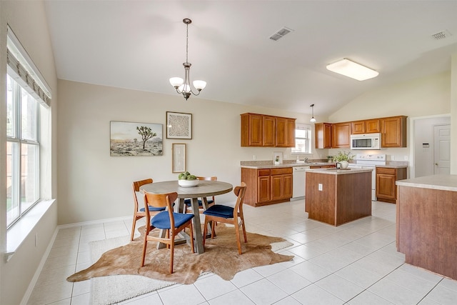 kitchen featuring lofted ceiling, light tile patterned floors, a kitchen island, white appliances, and decorative light fixtures