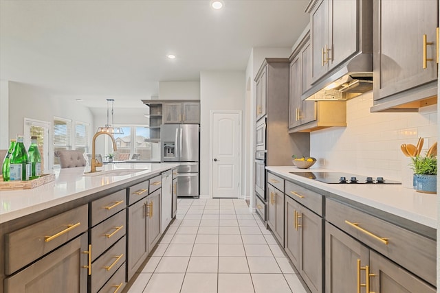 kitchen with stainless steel appliances, sink, light tile patterned flooring, pendant lighting, and tasteful backsplash