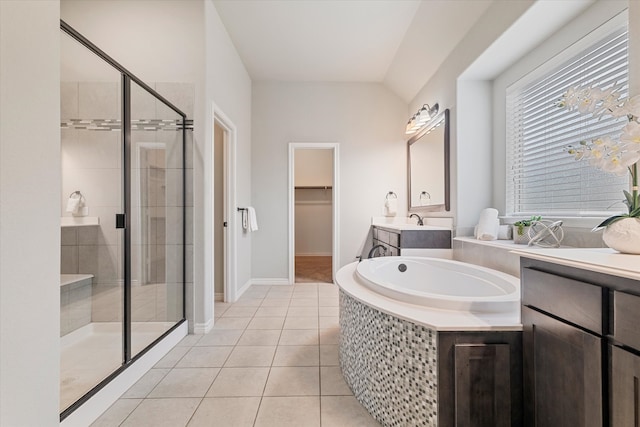 bathroom featuring vanity, lofted ceiling, plus walk in shower, and tile patterned floors