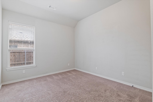 empty room with vaulted ceiling and carpet flooring