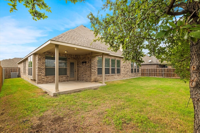 rear view of property with a patio, central AC, and a yard